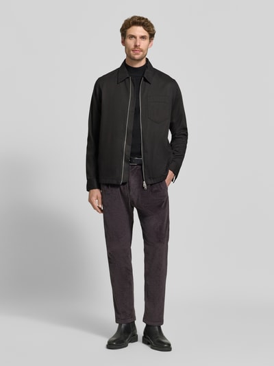 Männermodel trägt Straight Fit Hose aus Baumwoll-Mix Modell 'Chasy' von DRYKORN in Cord-Optik, dunkle Farben, Ganzkörperansicht von vorne. Elastischer Stoff, Gesäßtaschen, Knopf- und Reißverschluss, context: Herren Hose, Bundweite 40 cm, Innenbeinlänge 71 cm.