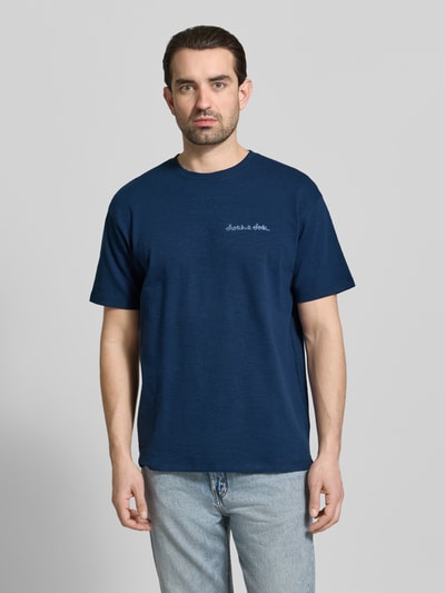 Männermodel trägt T-Shirt mit Label-Stitching von Scotch & Soda in Blau, Reine Baumwolle, Regular-Fit, Rundhalsausschnitt, Ganzkörperansicht von vorne. Rückenlänge bei Größe M: 69 cm.