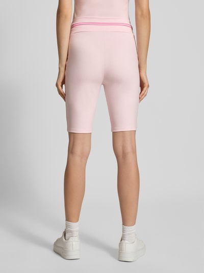 Kobiece modelka ma na sobie spodenki kolarki z Mieszanka lyocellu i elastanu Model 'Roxie' od OH APRIL, Dopasowany krój, elastyczny pas z nadrukiem z logo, Szerokość w rozmiarze S: 36 cm, Długość wewnętrzna nogawki w rozmiarze S: 24 cm, jasnoróżowy kolor, Ganzkörperansicht Rückansicht.