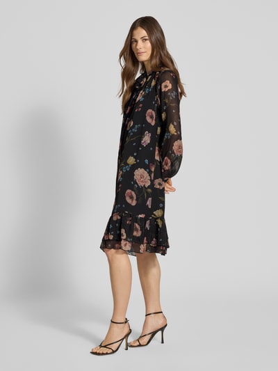 Vrouwenmodel draagt Knielanges Kleid mit Schluppe van Oui, zwarte A-lijn jurk met all-over look en laagjeslook, knielengte, ruglengte maat 36: 99 cm, borstwijdte maat 36: 52 cm, mouwlengte maat 36: 54 cm, geheellichaamsaanzicht van voren.