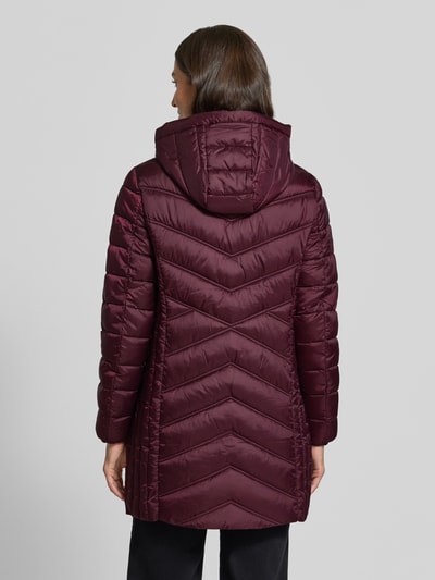 Männermodel trägt Steppmantel mit Zweiwege-Reißverschluss von Christian Berg Woman Selection, krój slim fit, kolor bordowy, kaptur z troczkiem, kieszenie na zamek, długość tyłu w rozmiarze 36: 83 cm, szerokość ramion w rozmiarze 36: 40 cm, szerokość klatki piersiowej w rozmiarze 36: 48 cm, długość rękawa w rozmiarze 36: 65 cm, widok całej sylwetki z tyłu