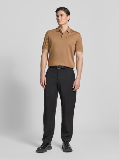 Männermodel trägt Regular Fit Poloshirt mit Brusttasche und Label-Stitching von bugatti in Braun, Polokragen, Knopfleiste, Ganzkörperansicht von vorne. Rückenlänge bei Größe M: 70 cm.