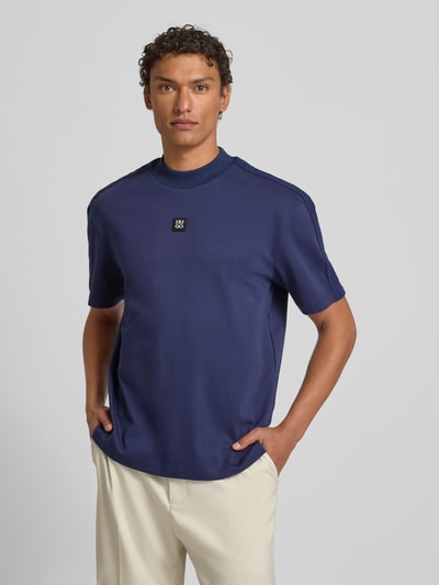 Männermodel trägt Relaxed Fit T-Shirt aus reiner Baumwolle Modell 'DANOVOTI' von HUGO, Optik: Unifarben, Ganzkörperansicht von vorne.