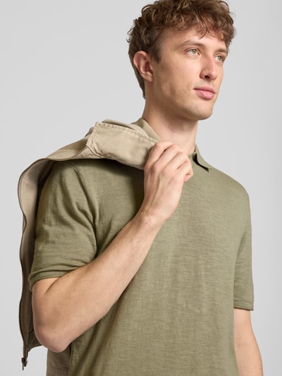 Männermodel trägt Slim Fit Poloshirt in Strick-Optik Modell 'Kane' von Jack & Jones aus reiner Baumwolle, Nahaufnahme Oberkörper.