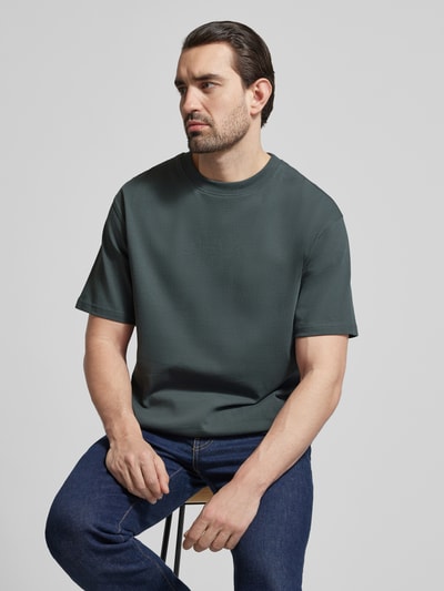 Männermodel trägt Relaxed Fit T-Shirt aus Bio-Baumwoll-Mix Modell 'MAARKOS' von Armedangels, Optik: Unifarben, Ganzkörperansicht von vorne