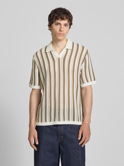 Männermodel trägt Regular Fit Poloshirt aus Baumwoll-Mix Modell 'THUE' von Only & Sons mit gestreiftem Lochstrickmuster, V-Ausschnitt, kurzarm, Struktur in Beige und Weiß, Ganzkörperansicht von vorne.