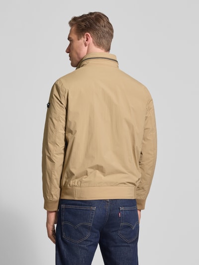 Mannenmodel draagt Regular Fit Jack met opstaande kraag van bugatti, beige, logodetail, elastisch mouwboord, ruglengte 65 cm, ganzkörperansicht rückansicht.