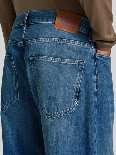 Männermodel trägt Loose Fit Jeans Modell 'THE PITCH' von Scotch & Soda, Used-Look, reine Baumwolle, Nahaufnahme Rückansicht.