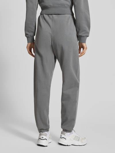 Modelka kobieca nosi High Waist Sweatpants mit elastischem Bund od Pegador w szarym kolorze, bawełniana mieszanka, widok całej sylwetki od tyłu.