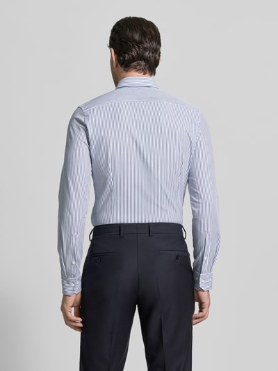 Męski model nosi Slim Fit Freizeithemd mit Kentkragen Modell 'Performance' od OLYMP No. Six, krój slim fit, bawełna elastyczna, paski, długi rękaw, sportowe mankiety, długość pleców w rozmiarze 40: 78 cm, szerokość ramion w rozmiarze 40: 45 cm, długość rękawa w rozmiarze 40: 68 cm, widok całej sylwetki z tyłu.