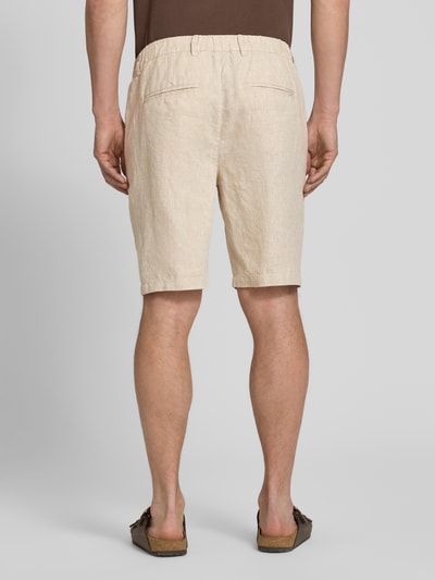 Mężczyzna nosi Leinen Shorts mit Eingrifftaschen Modell 'PANDRUP' od Casual Friday, beżowe, krój straight fit, widok całej sylwetki z tyłu, czysta faktura lnu, szerokość w rozmiarze M: 44 cm, długość nogawki od wewnątrz: 23 cm.