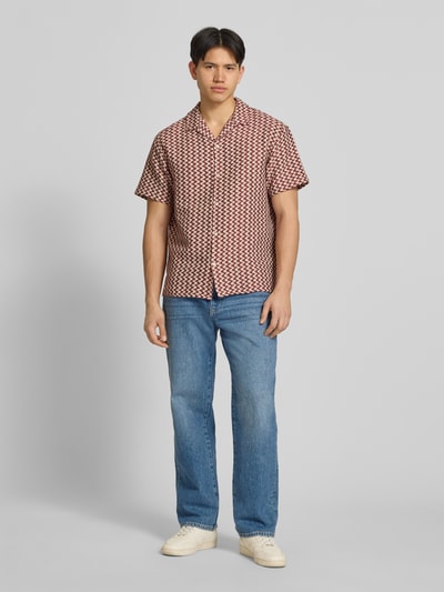 Mannenmodel draagt Regular Fit Freizeithemd im Allover-Look Modell 'MONTAUK' van Jack & Jones, katoenmix, reverskraag, knoopsluiting, allover patroon, rechte broek, ontspannen look, volle lichaamsweergave van voren.