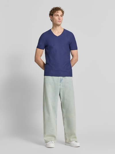 Mannelijk model draagt T-shirt met V-hals en rolzoom van MCNEAL in blauw, puur katoen, regular fit, ruglengte maat M 81 cm. Ganzkörperansicht von voren.