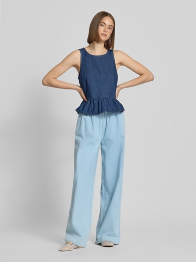 Frauenmodel trägt Pull-on-Jeans mit weitem Bein und Kordelzug von REVIEW aus reiner Baumwolle, helle Blautöne, Ganzkörperansicht von vorne.