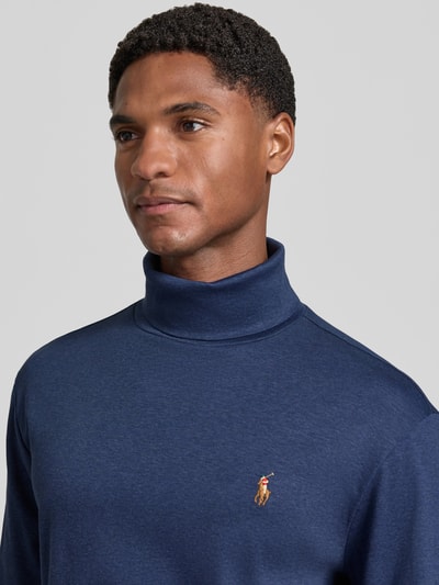 Männermodel trägt Regular Fit Rollkragenpullover aus reiner Baumwolle von Polo Ralph Lauren in Dunkelblau, Nahaufnahme Oberkörper.