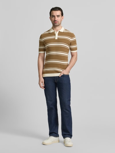 Männermodel trägt Slim Fit Poloshirt in Strick-Optik von MCNEAL aus reiner Baumwolle, braun mit weißen Streifen, Ganzkörperansicht von vorne.