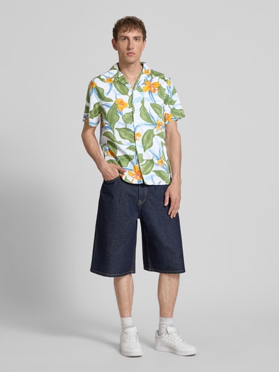 Männermodel trägt Regular Fit Freizeithemd mit Reverskragen von Superdry, farbig gemustert, Reine Baumwolle, Modern Fit, Ganzkörperansicht von vorne. Rückenlänge bei Größe M: 66 cm, Schulterbreite bei Größe M: 41 cm, Ärmellänge bei Größe M: 18 cm, Knopfleiste.