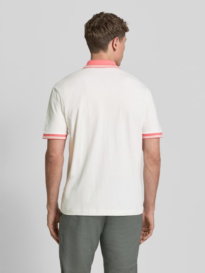 Männermodel trägt Regular Fit Poloshirt aus reiner Baumwolle Modell 'BLOCKS' von BOSS Orange in Weiß mit rosa Details, Piqué-Struktur, Ganzkörperansicht Rückansicht.