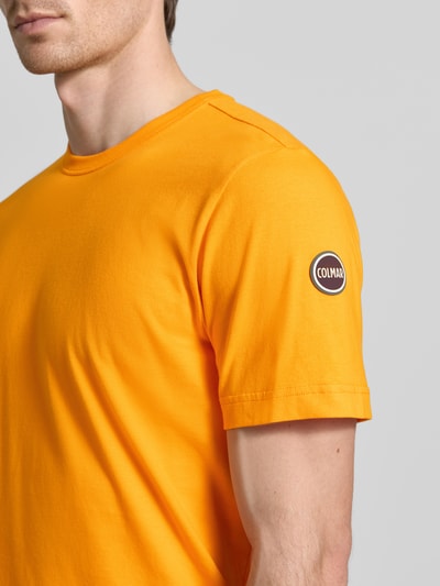 Männermodel trägt Regular Fit T-Shirt aus Baumwolle von Colmar Originals in leuchtendem Orange, Nahaufnahme Oberkörper.