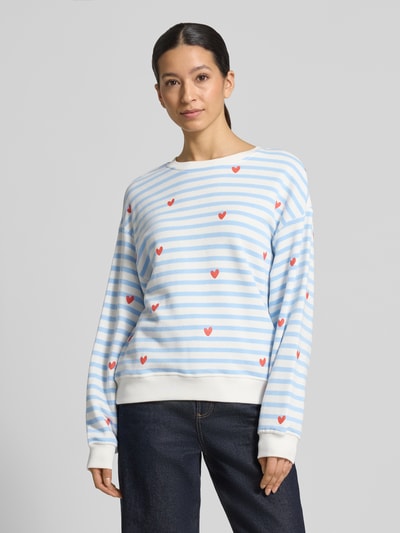 Frauenmodel trägt Sweatshirt im Allover-Look von Smith and Soul, blau-weiß gestreift mit roten Herzen, Rundhalsausschnitt, Ganzkörperansicht von vorne.