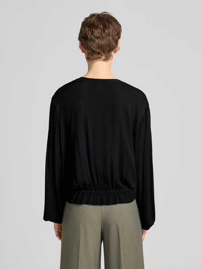 Frauenmodel trägt Bluse aus Viskose mit Schlüsselloch-Ausschnitt von Emily Van den Bergh in Schwarz, elastische Abschlüsse, Ganzkörperansicht Rückansicht.