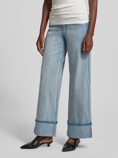 Modelka nosi Wide Leg Jeans mit fixiertem Aufschlag Modell 'Dikan' od My Essential Wardrobe, jasnoniebieski bawełniany miks z domieszką stretchu, rozszerzany fason, 5 kieszeni, guzik i zamek, stały mankiet, szerokość w rozmiarze 27/32: 36 cm, długość wewnętrzna nogawki 80 cm, zdjęcie całej sylwetki z przodu.