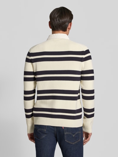 Männermodel trägt Slim Fit Poloshirt aus katoenmix von Lindbergh, heren poloshirt, polokraag, met lange mouwen, ruglengte maat M 70 cm, mouwlengte maat M 69 cm, gestreept in crème en donkerblauw, fijngebreide textuur, effen kraag en boorden. Ganzkörperansicht Rückansicht.