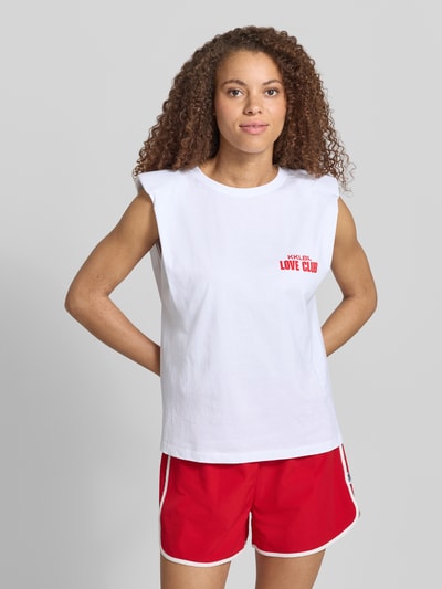 Frauenmodel trägt weißes Damen Tanktop mit Statement-Print Modell 'Love Club' von Karo Kauer aus Reine Baumwolle, Straight Fit, Rundhalsausschnitt, kombiniert mit roten Shorts, Rückenlänge bei Größe S: 57 cm, Ganzkörperansicht von vorne.