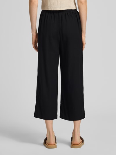Männermodel trägt Regular Fit Culotte aus Viskose-Leinen-Mix Modell 'MYMILO' von Vero Moda, czarny, flammgarn, elastyczny pas, kieszenie, krój regular fit, widok całej sylwetki z tyłu.