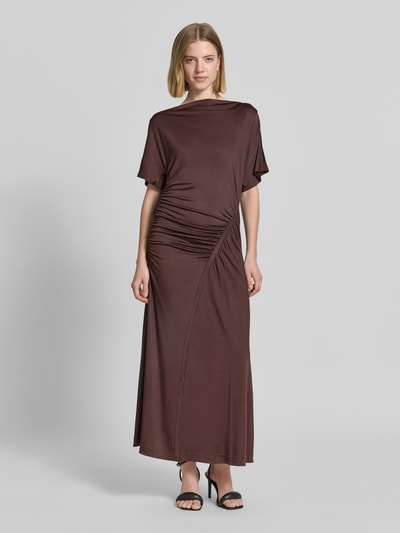 Frauenmodel trägt Slim Fit Maxikleid aus Viskose-Mix Modell 'ECAREN' von BOSS in Braun mit Raffungen, unifarben, Ganzkörperansicht von vorne.