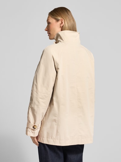 Vrouwenmodel draagt 'Trenchcoat mit Stehkragen und Ärmelriegeln' van Fuchs Schmitt in beige, regular fit, rugaanzicht, knoopsluiting, steekzakken, staande kraag, mouwriempje, ruglengte 72 cm, schouderbreedte 36 cm, borstwijdte 56 cm, mouwlengte 53 cm, detailopname rugaanzicht.