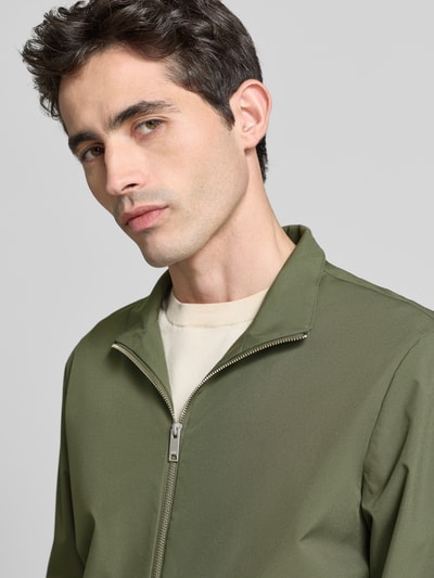 Männermodel trägt Jacke mit Stehkragen und Eingrifftaschen Modell 'Joshu' van Casual Friday in olijfgroen, regular fit, ritssluiting, nahaufnahme oberkörper