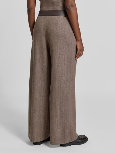Frauenmodel trägt Wide Leg Hose aus Schurwoll-Mix mit Eingrifftaschen von Armani Exchange in Braun, fein strukturierte Oberfläche, Ganzkörperansicht Rückansicht. Damen Hose, Schurwoll-Mix mit Seiden-Anteil, Knopfverschluss, Bundweite Größe 36: 36 cm, Innenbeinlänge Größe 36: 83 cm.