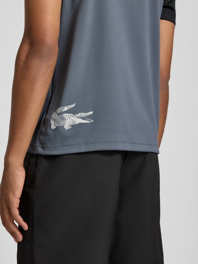 Männermodel trägt Regular Fit Sport-T-Shirt im Colorblock-Design von Lacoste Sport, Grau und Schwarz, Nahaufnahme Rückenbereich.