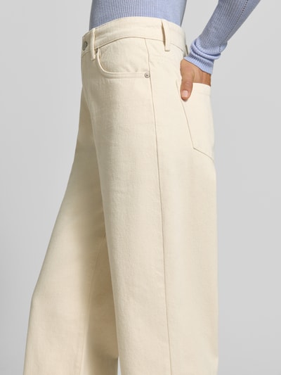Frauenmodel trägt Wide Fit Jeans aus reiner Baumwolle von MYON, cremefarbener Stoff, 5-Pocket-Design, Nahaufnahme Oberkörper.