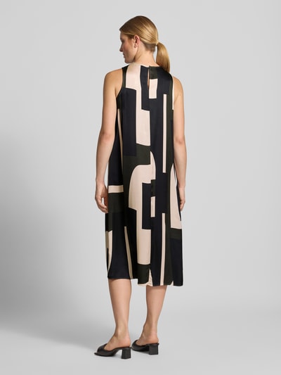 Frauenmodel trägt Midikleid aus reiner Viskose Modell 'Quileena' von someday, lockere Passform, abstraktes Muster, Ganzkörperansicht Rückansicht.