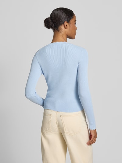 Frauenmodel trägt Slim Fit Strickjacke aus Viskose-Mix Modell 'Wonder' von Vero Moda, Optik: Unifarben, Rippstrick, Ganzkörperansicht Rückansicht.