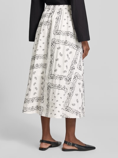 Frauenmodel trägt Ausgestellter Maxi-Rock aus reiner Baumwolle Modell 'CARAVAN' von Weekend Max Mara, weiß mit schwarzem Allover-Muster, Popeline-Textur, elastischer Bund, Ganzkörperansicht Rückansicht.