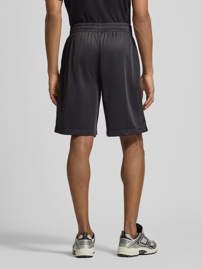Männermodel trägt Shorts mit Logo und Eingrifftaschen von EA7 Emporio Armani, Relaxed-Fit, elastischer Bund, Ganzkörperansicht Rückansicht