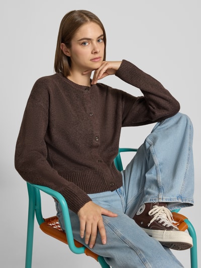 Kobiece modelka nosi kardigan z dodatkiem wełny Model 'NATALIE' od JJXX, elastyczna mieszanka materiałów, imitacja dzianiny, okrągły dekolt, dopasowany krój, ciemnobrązowy, dżinsy, pełny widok z przodu, kontekst: długość tyłu dla rozmiaru S 48 cm, długość rękawów 55 cm.