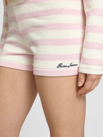 Frauenmodel trägt Strickshorts mit Streifenmuster und Label-Stitching von Guess Jeans aus Reine Baumwolle, Slim-Fit, Nahaufnahme Oberschenkel.