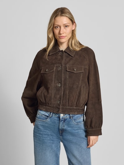 Vrouwenmodel draagt lederjacke met borstzakken model 'MARWICK' van Drykorn, echt leer, straight fit, kentkraag, knoopsluiting, borstzakken met knoopsluiting, zij-ingrijpzakken, donkerbruin, gladde textuur, volledige lichaamsaanzicht van voren.