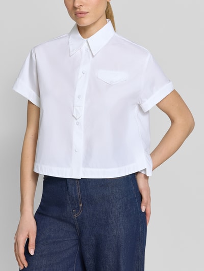 Frauenmodel trägt Boxy Fit Bluse mit Brusttasche von Luisa Cerano aus reiner Baumwolle in Weiß, mit Hemdblusenkragen und Knopfleiste, Nahaufnahme Oberkörper.