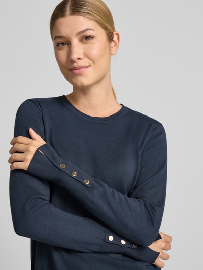 Vrouwenmodel draagt gebreide pullover van viscosemix Model 'KATIE' van FREE/QUENT in recht model, knopen aan mouwboord, Nahaufnahme bovenlichaam.