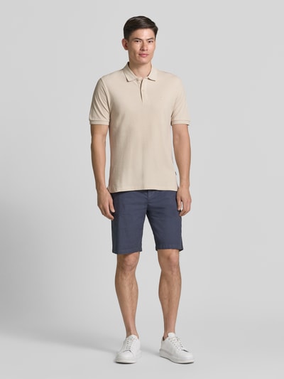 Męski model nosi Slim Fit Poloshirt mit Stitching von Jack & Jones Premium z bawełny, krój slim fit, haft, listwa guzikowa, długość tyłu w rozmiarze M: 70 cm, ganztkörperansicht von vorne.