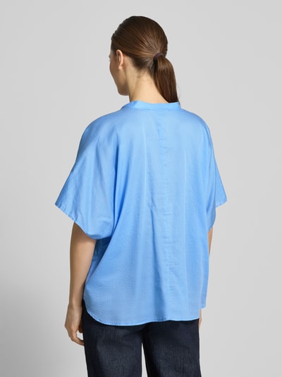 Frauenmodel trägt Relaxed Fit Bluse mit Rüschen Modell 'DAISY' von 0039 Italy aus reiner Baumwolle in Hellblau, Ganzkörperansicht Rückansicht