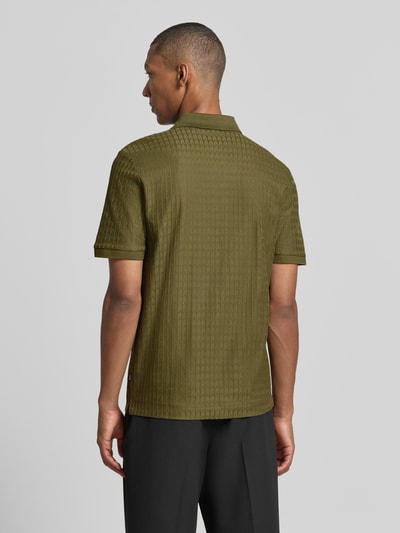 Männermodel trägt Regular Fit Poloshirt aus reiner Baumwolle Modell 'Parley 321' von BOSS in Olivgrün, Strukturmuster, Ganzkörperansicht Rückansicht, Herren Poloshirt von BOSS.