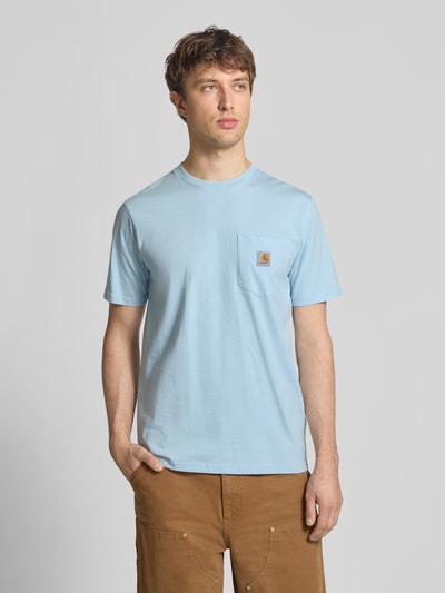 Männermodel trägt Regular Fit T-Shirt mit Logo-Patch von Carhartt Work In Progress in Hellblau, reine Baumwolle, Rundhalsausschnitt, Brusttasche, Ganzkörperansicht von vorne.