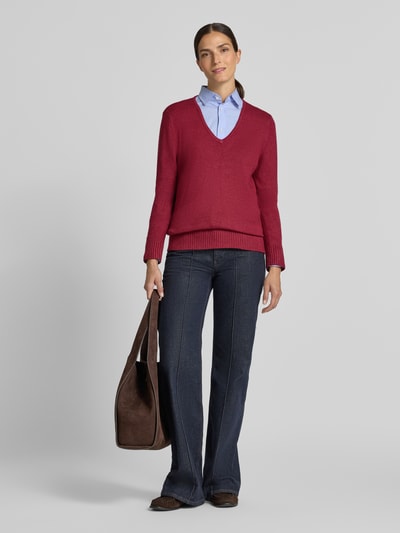 Frauenmodel trägt Regular Fit Sweatshirt aus Viskose-Anteil von Christian Berg Woman, V-Ausschnitt, gerippte Abschlüsse, rote Farbe, Jeans, Ganzkörperansicht von vorne.