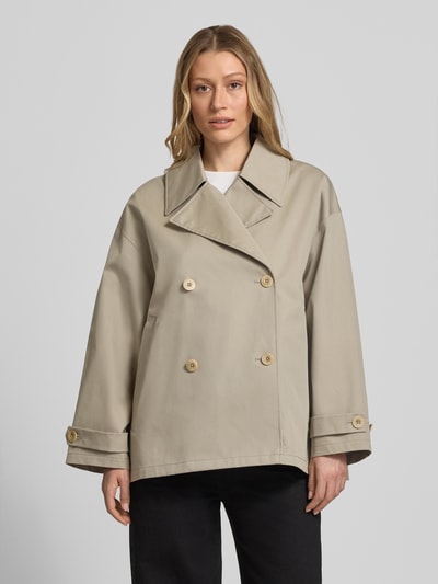 Frauenmodel trägt Trenchjacke mit Reverskragen Modell 'HEATHER' von G-LAB, gerader Schnitt, Knopfverschluss, Ärmelriegel, beige, Ganzkörperansicht von vorne. Rückenlänge bei Größe S 70 cm, Schulterbreite 48 cm, Brustweite 52 cm, Ärmellänge 51 cm.